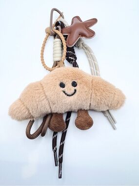 Plush Beige Croissant Bag Keychain Toy – Soft Smiley Accessoryy